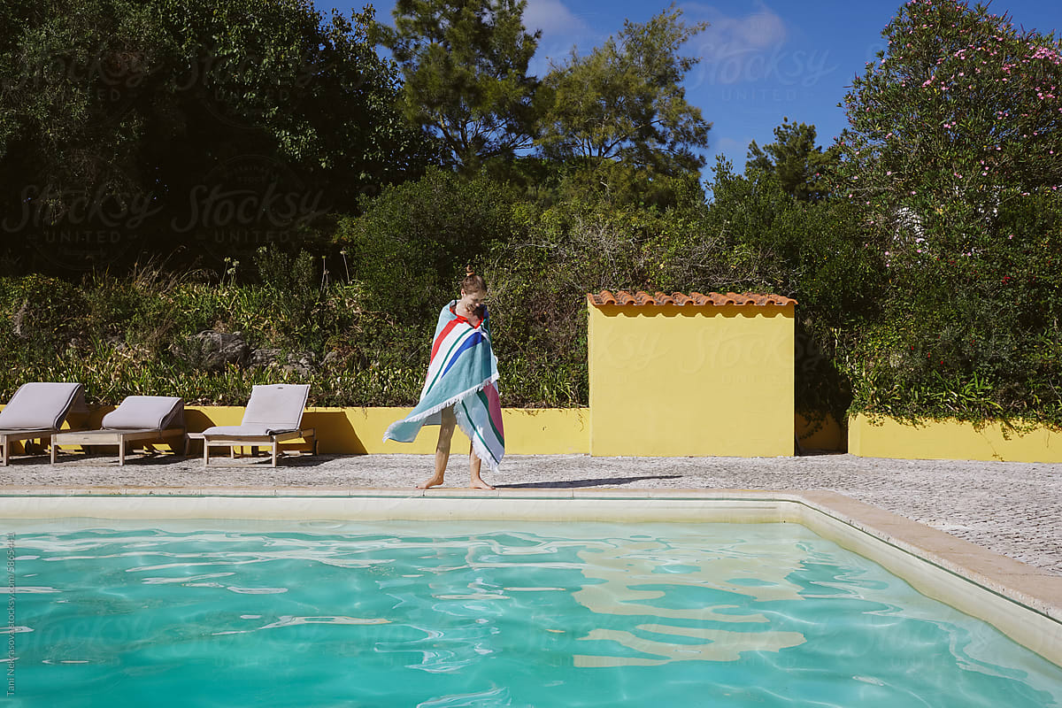 Full-length portrait of a girl by the pool in a colored towel,Portugal