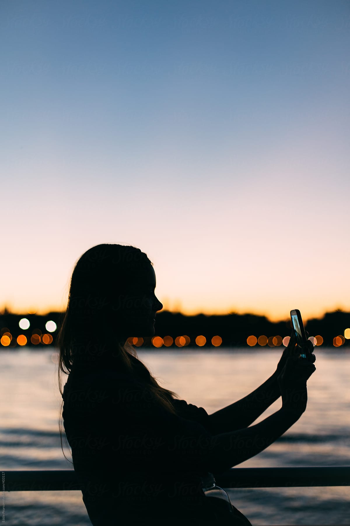 Silhouette profile shot of a woman taking a selfie