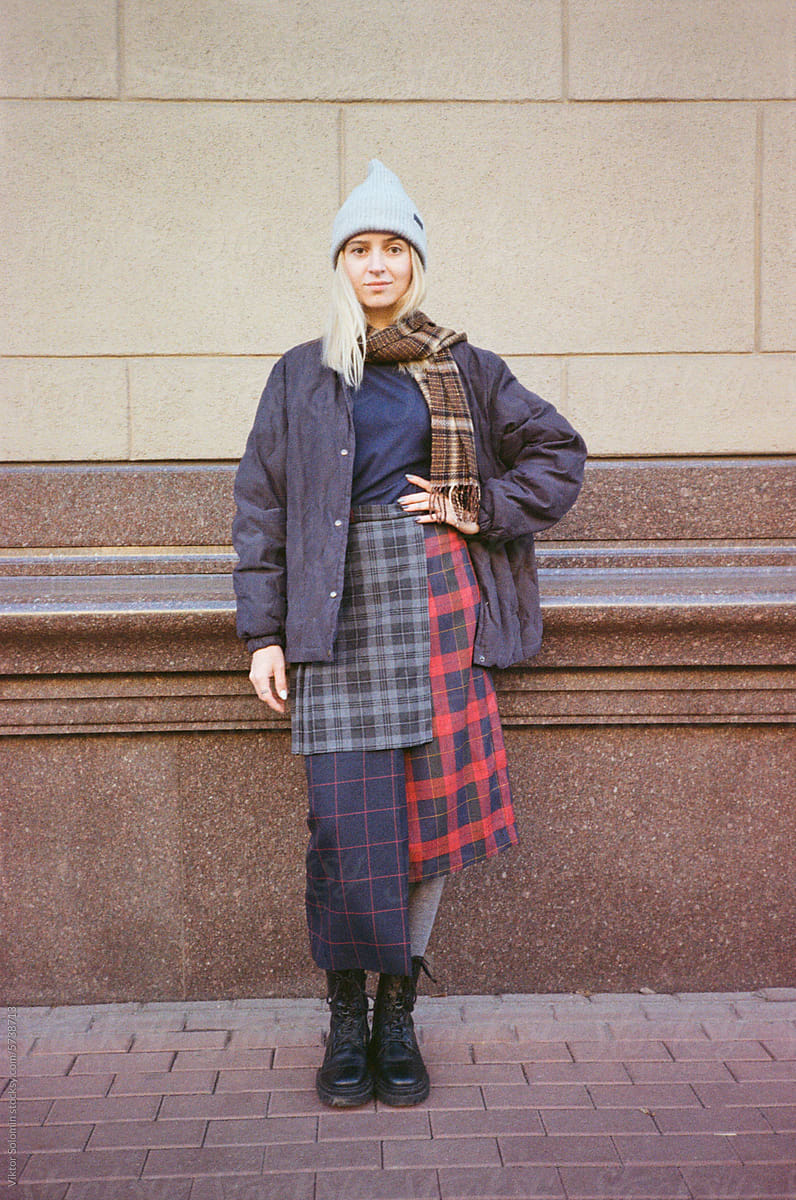 Smiling woman in trendy vintage outfit standing on street in winter