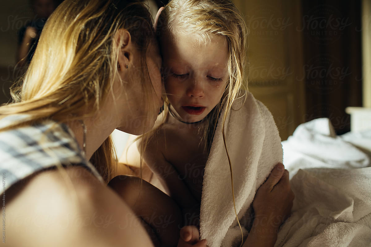 Mom hugs daughter tightly after bathing.