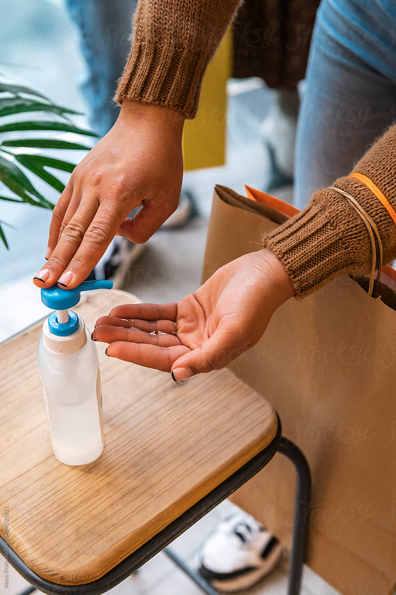 Multiracial woman using hand sanitizer