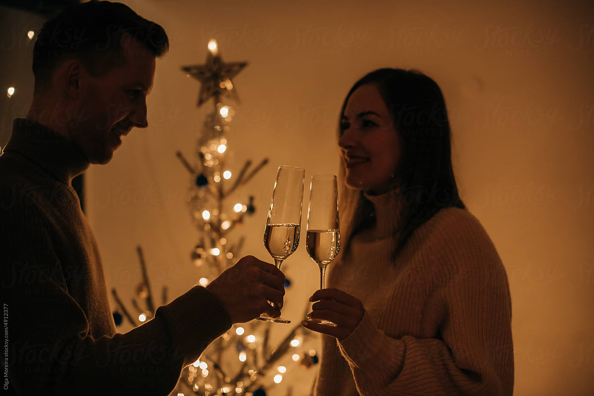 Couple toasting with Christmas tree on the background