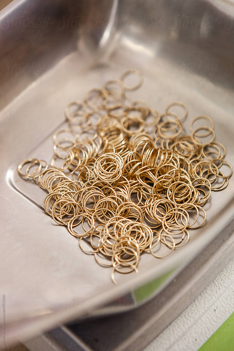 A pile of gold hoop earrings being weighed in a jewellery factory