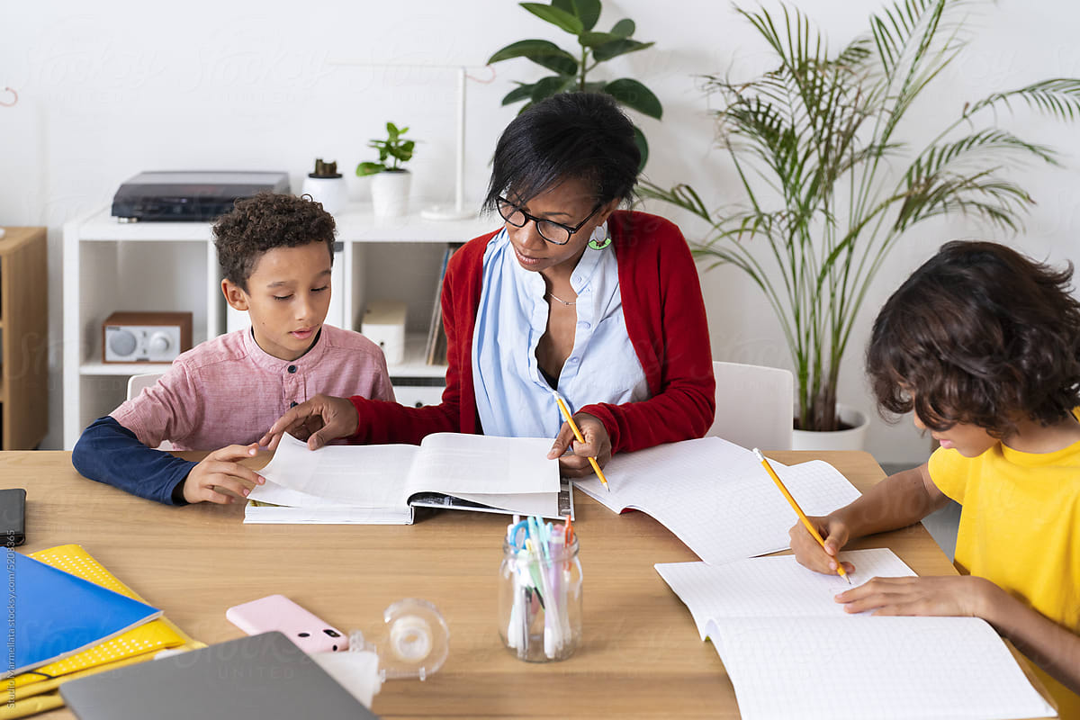 Black mother helping sons with homework