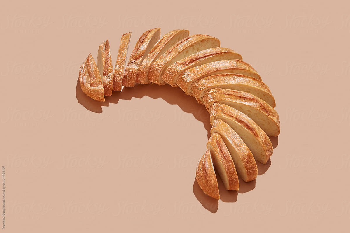 Sliced white bread, homemade in the form of semicircle on a pastel beige background with copy space.