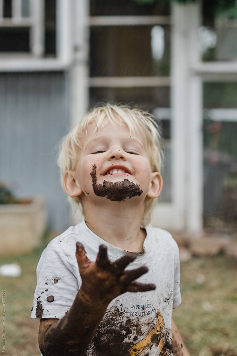 Young boy proudly decorates face with mud
