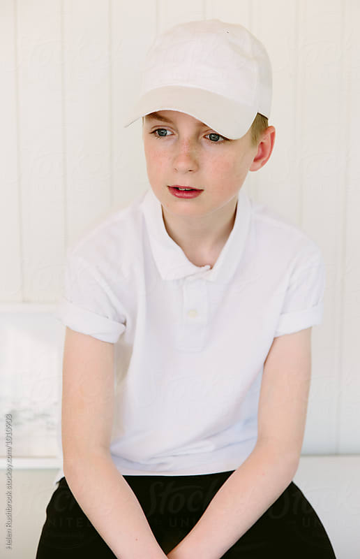 Teenage boy wearing a white baseball cap and polo shirt.
