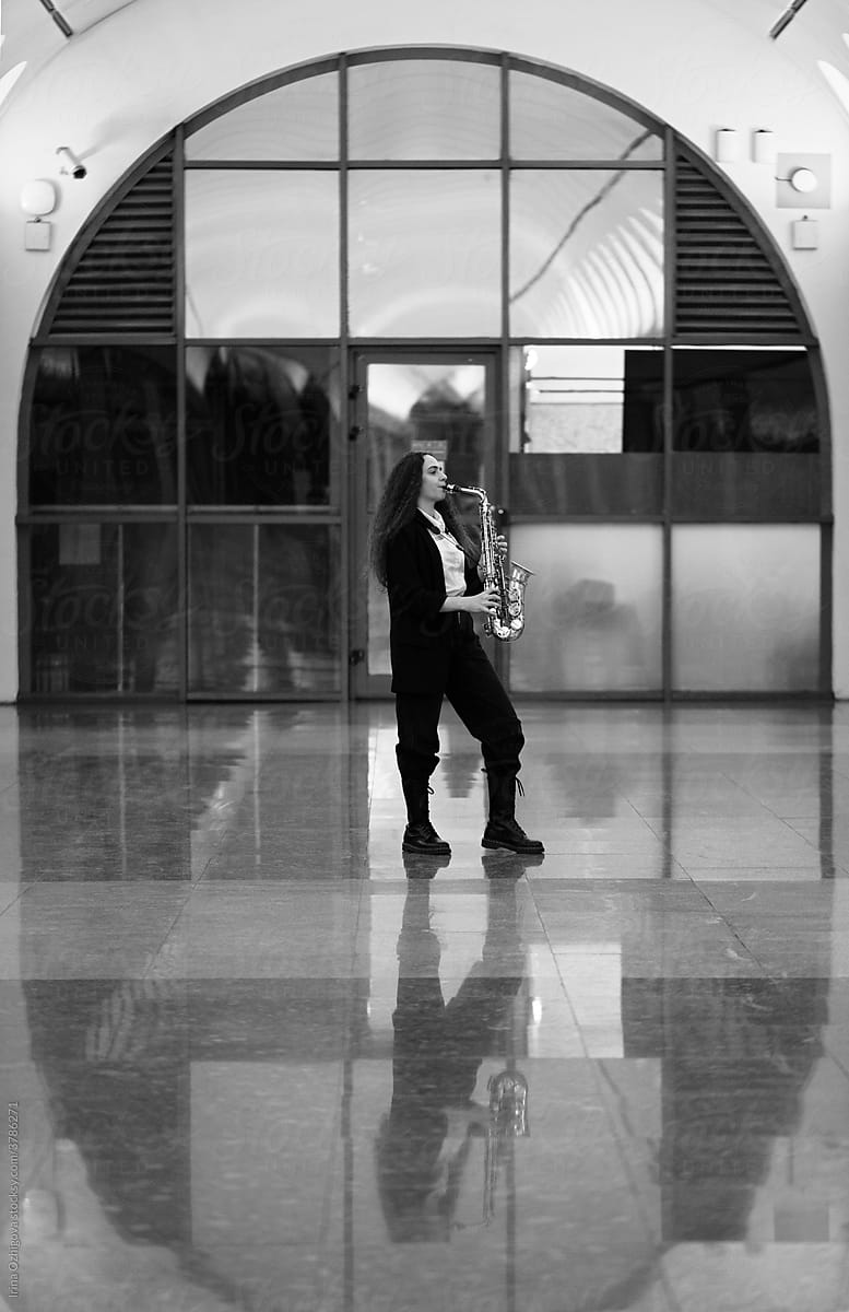 Girl playing sax in a subway