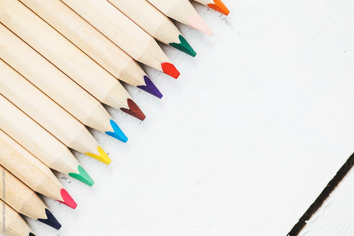 Set of colorful pencils against a white wooden background