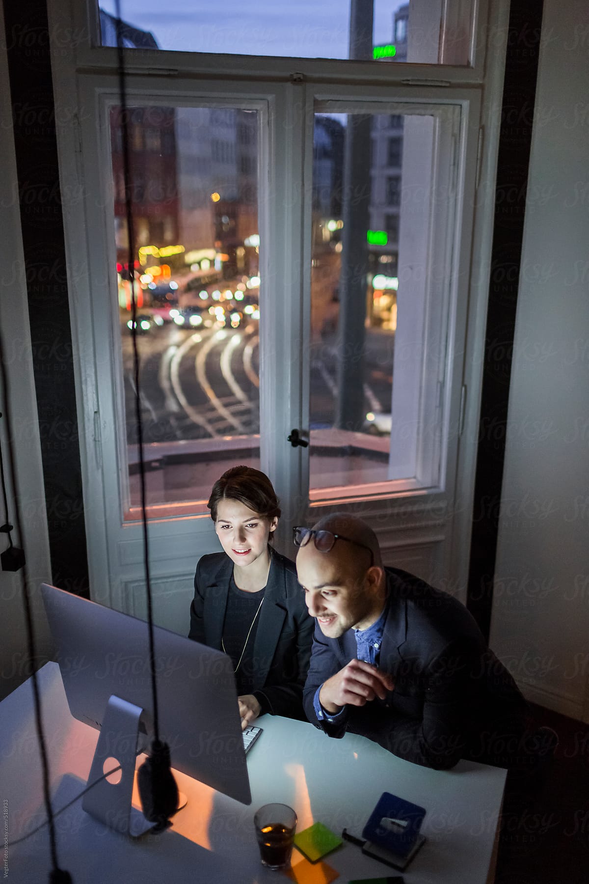 Two Young Business People Working Late