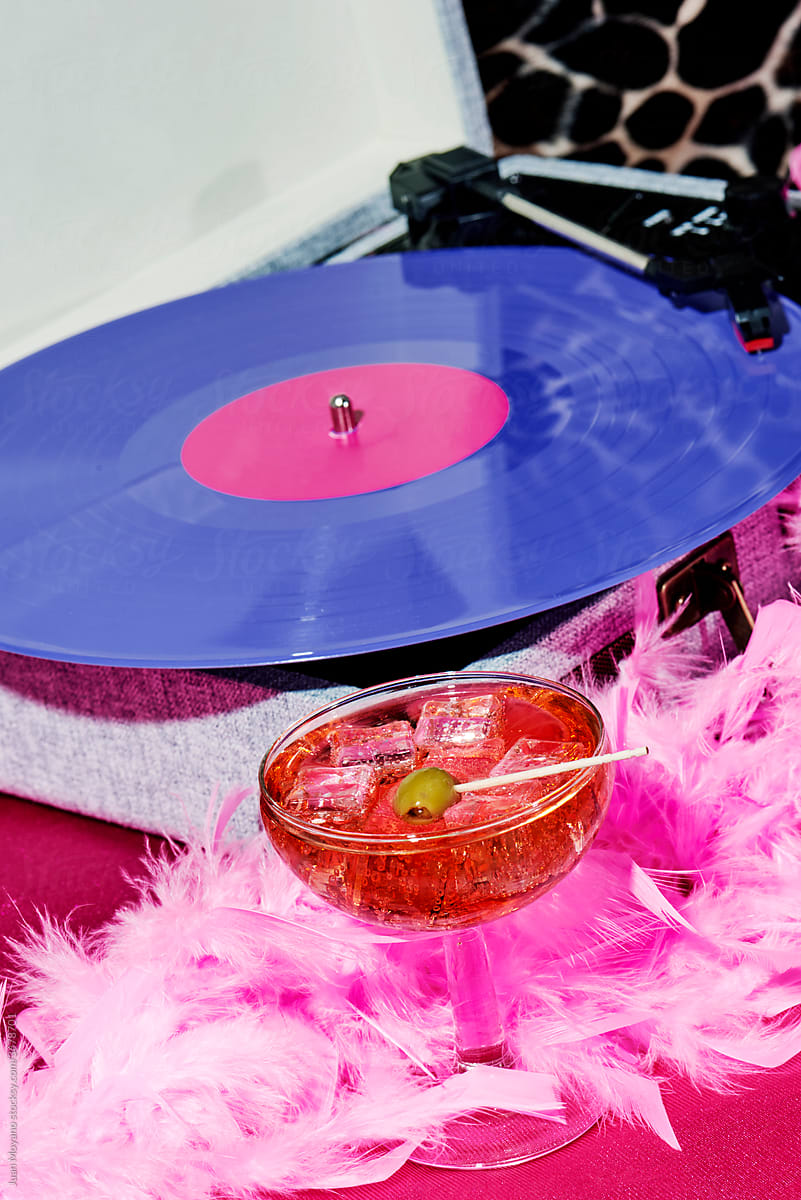 cocktail, feather boa and violet record in a portable turntable