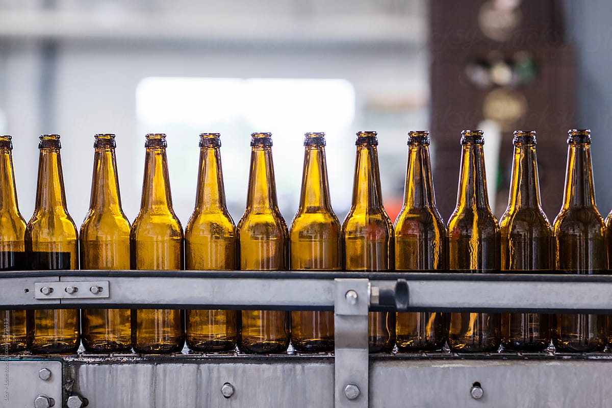 Closeup of empty beer bottles on a factory conveyor