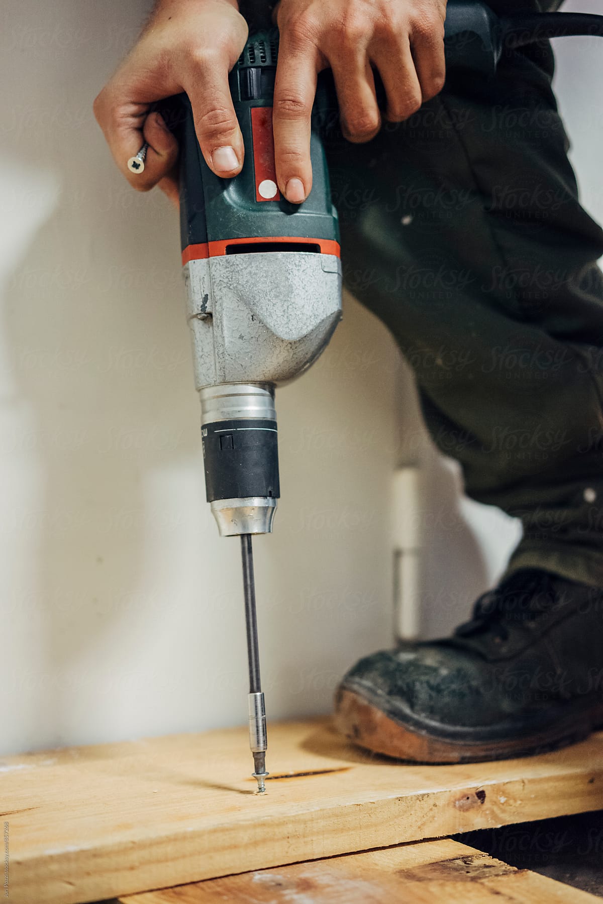 Builder using an electric screwdriver