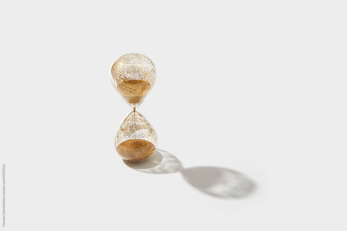 Old hourglass with flowing golden sand