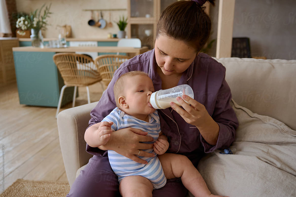 mother feeding baby formula from a bottle