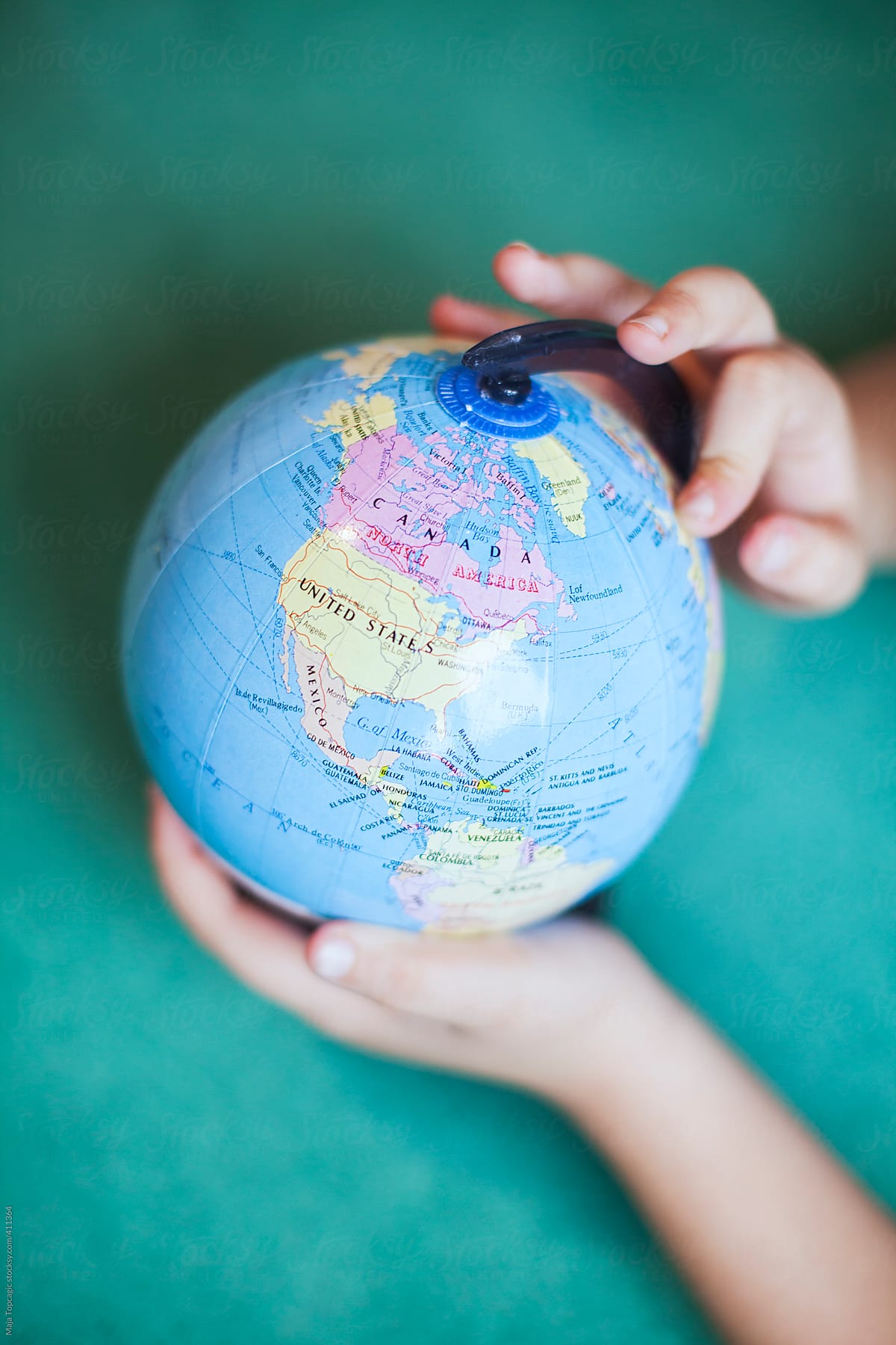 Little child hands holding a globe