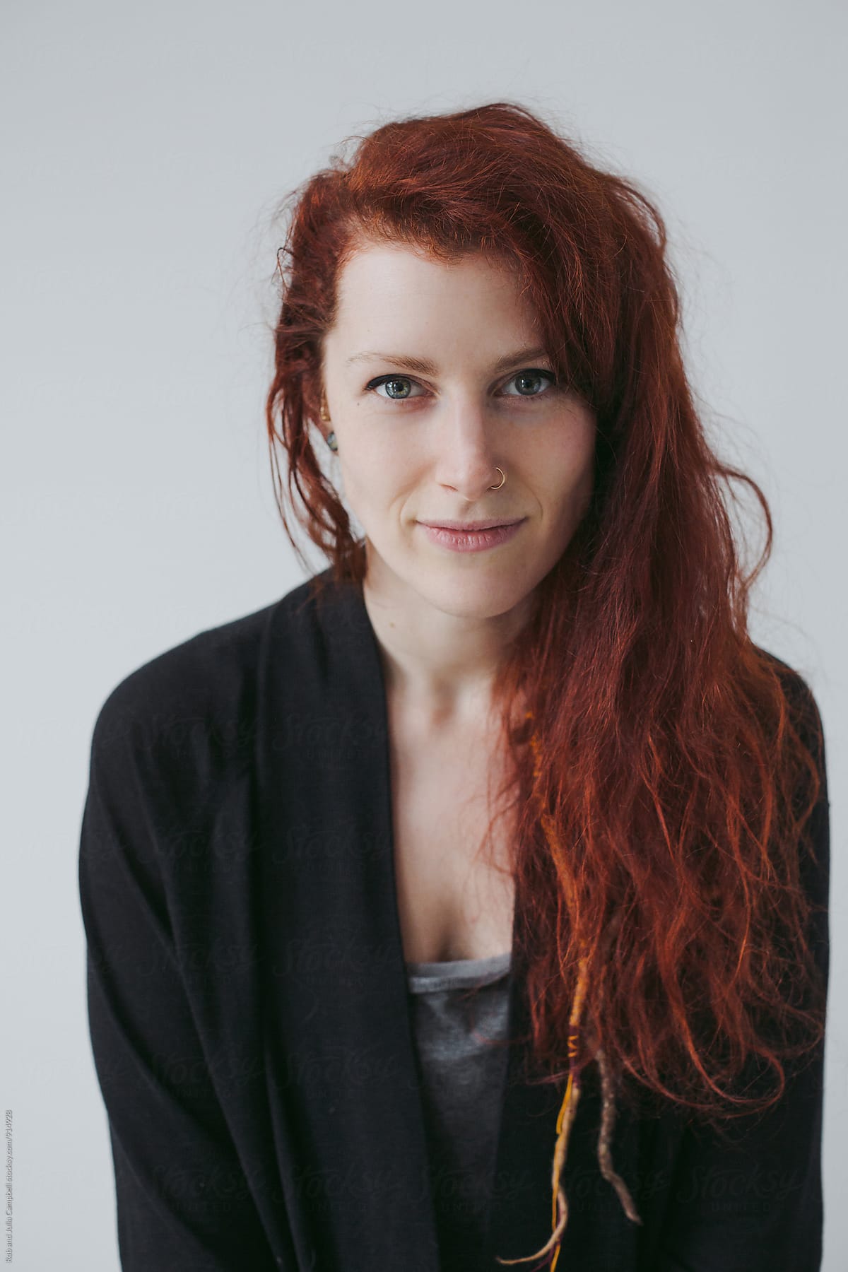 Portrait of mischevious red head woman on simple white background