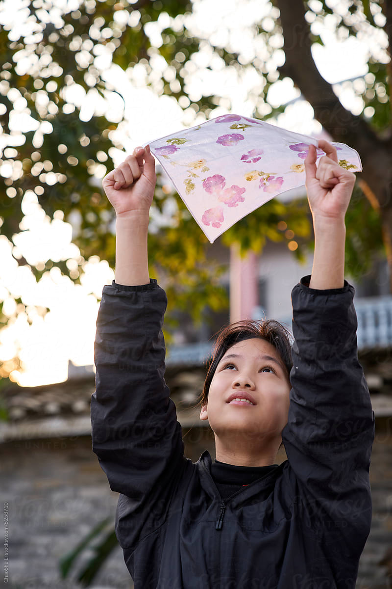 Asian girl is holding plant-dyed cloth works to dry