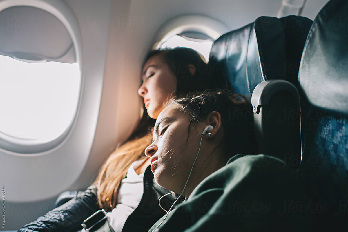 Two teenage girls sleeping on airplane