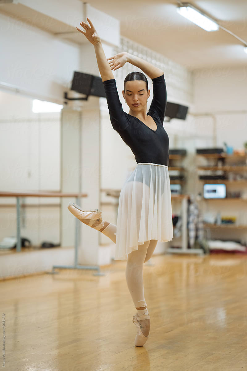 Graceful Hispanic ballerina performing dance in studio