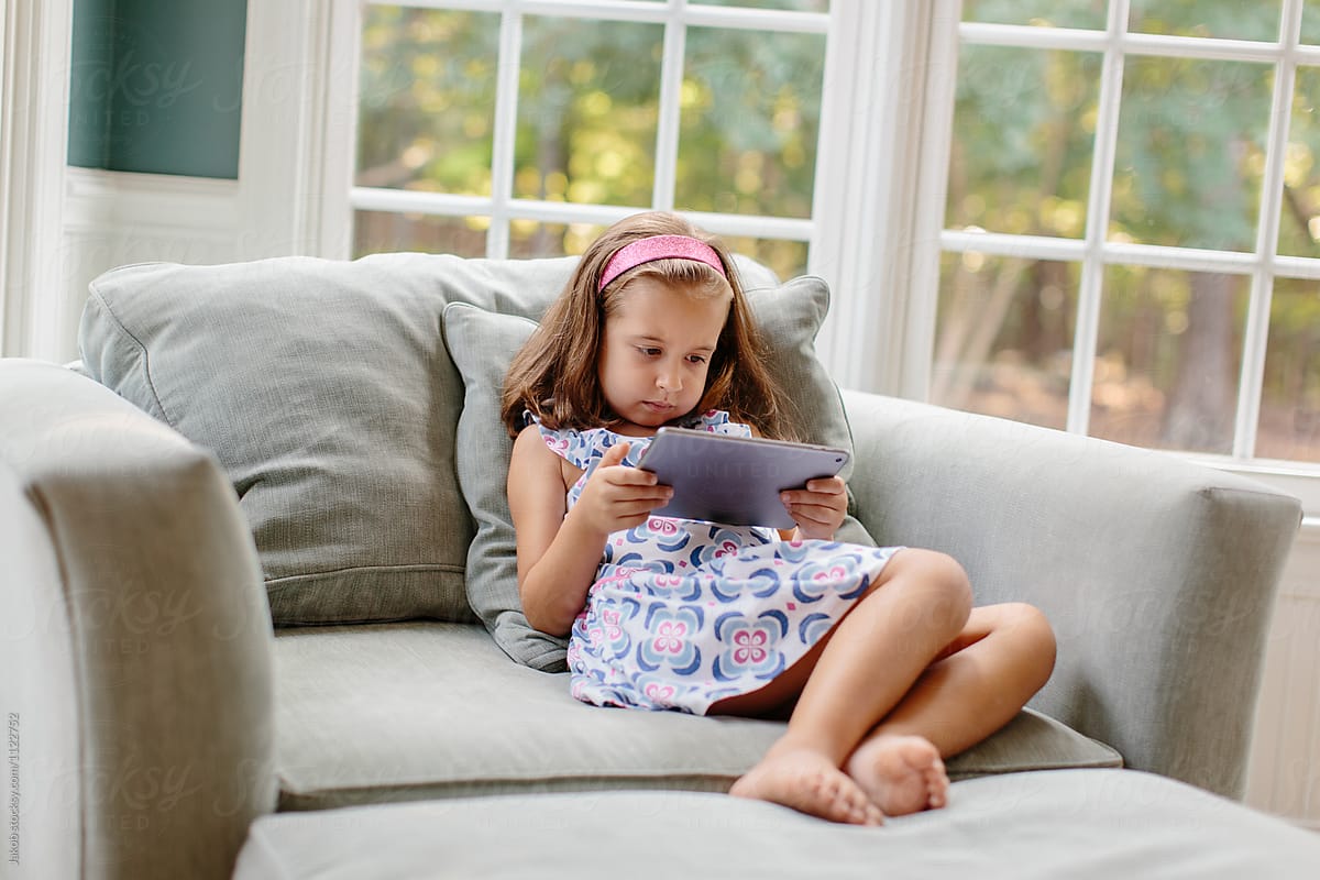 Beautiful young girl using a tablet at home
