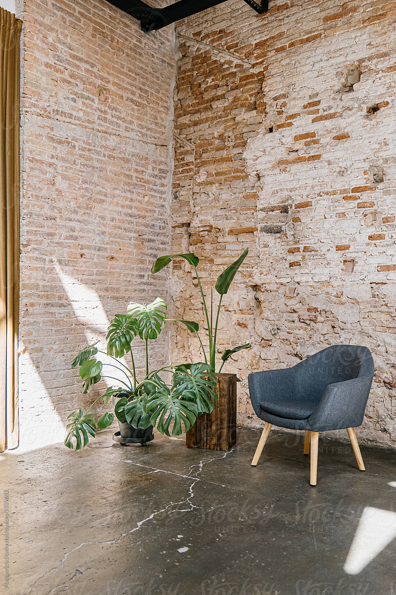 Armchair and plants in a brick wall