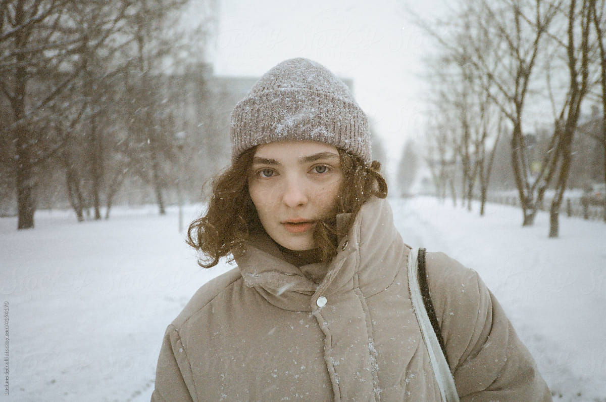 Portrait curly hair girl walking during a snow storm