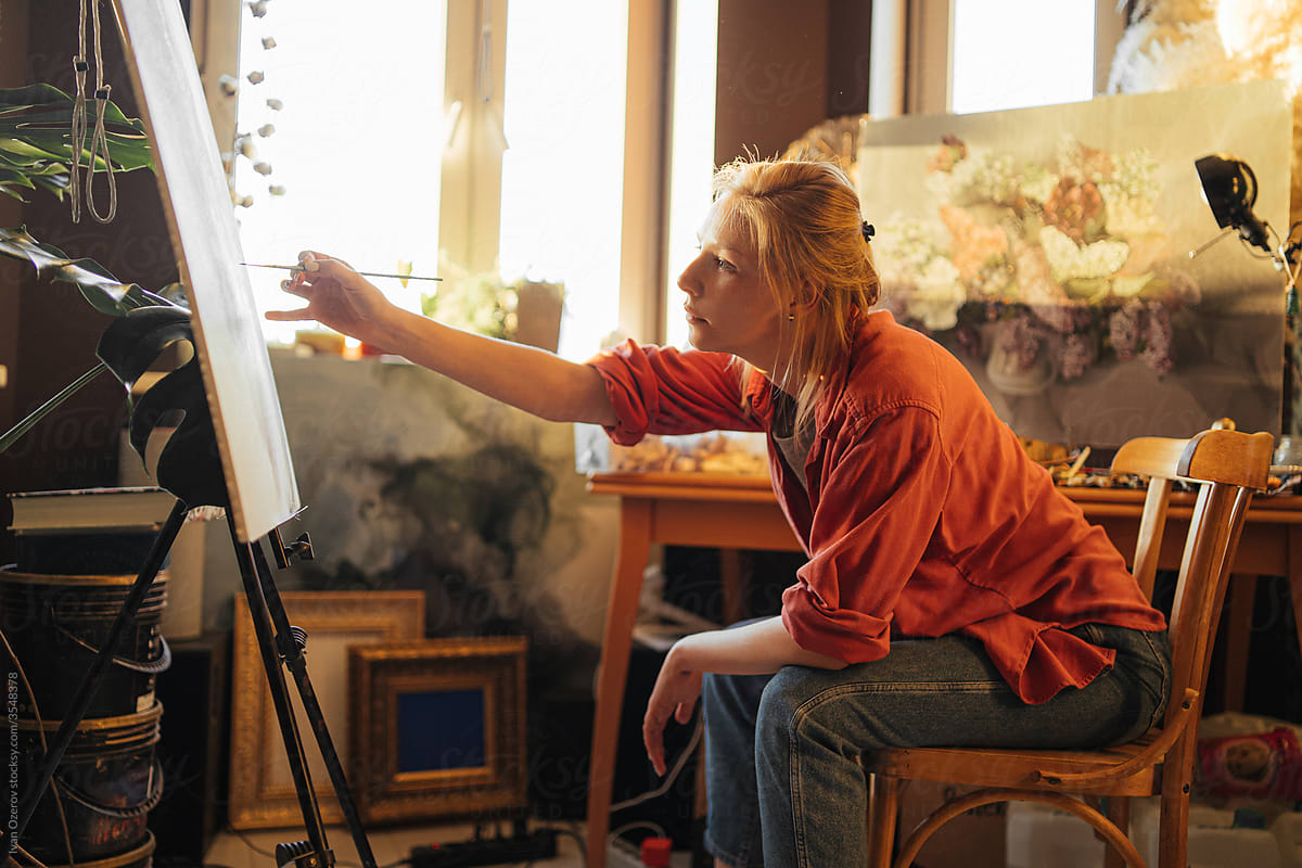 Female artist painting in cozy workshop