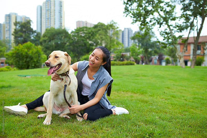 happy young asian woman outdoor with her dog