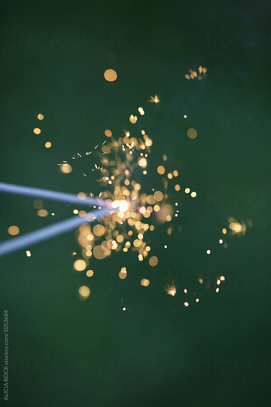 Close Up Of Two Joined Fourth Of July Sparklers Against A Green Background