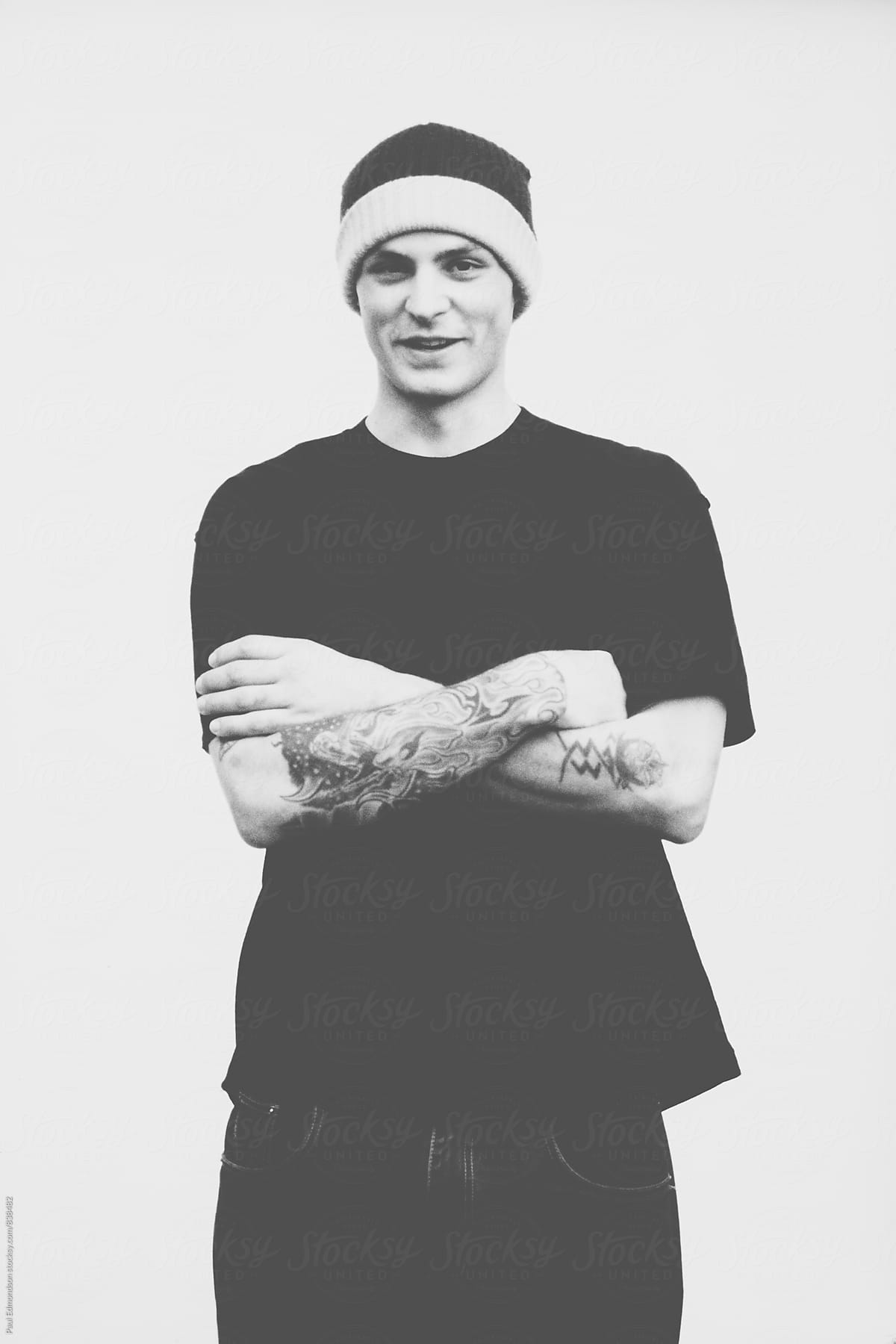 Portrait of young man with tattoos, wearing beanie cap