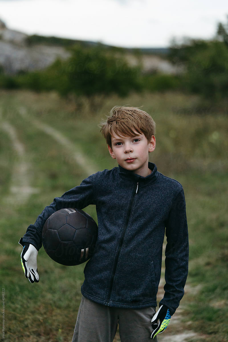 Portrait of cute little boy in sportswear with a soccer ball