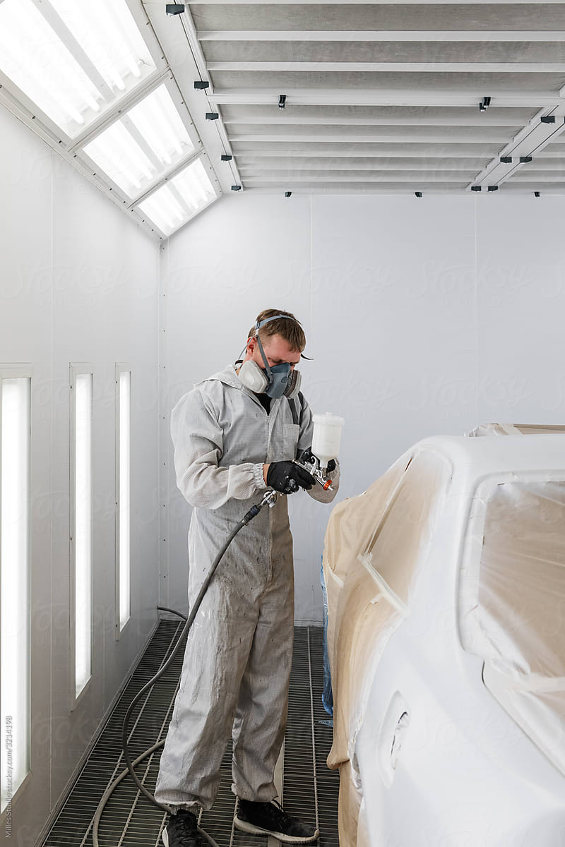 Technician painting modern vehicle door
