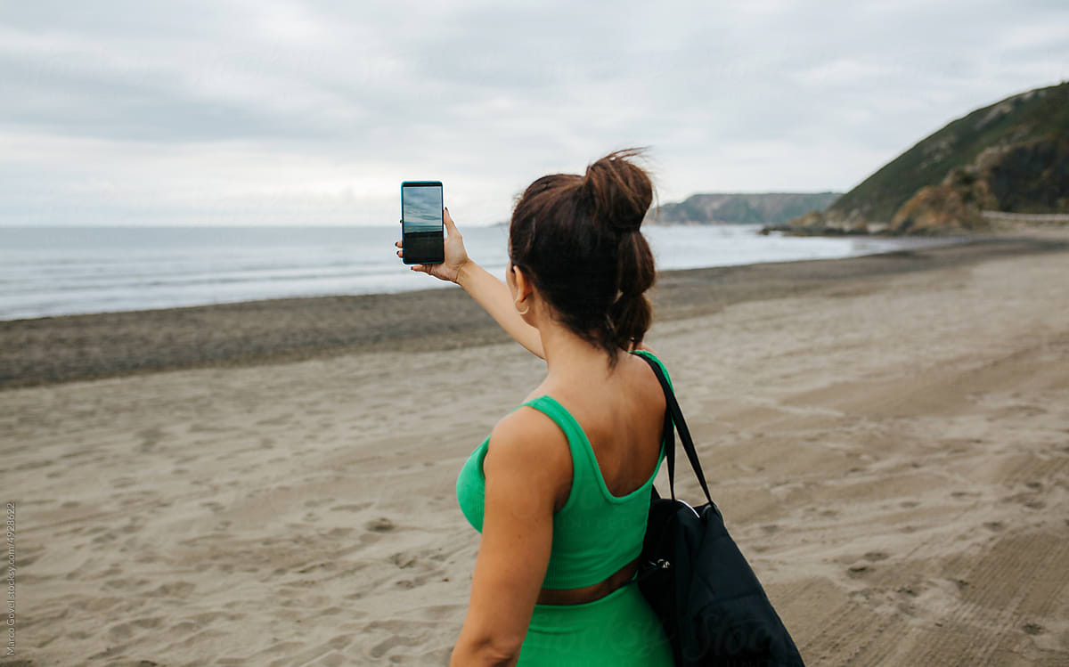 Woman taking photo of sea