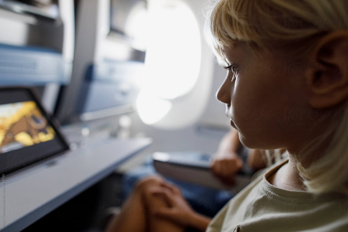A little girl watching video in an airplane