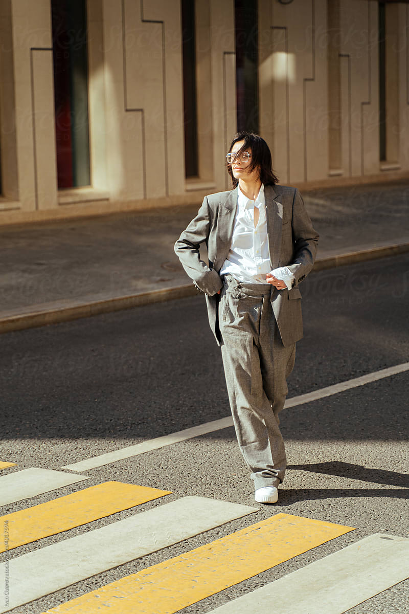Confident woman in suit walking in city