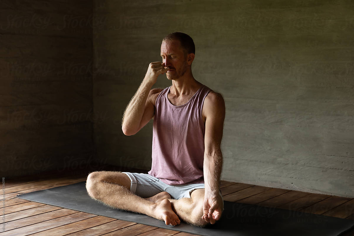 Adult yogi male doing breathing exercises