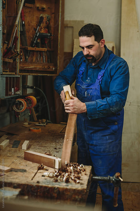 boat builder working with his wood plane in a wood workshop