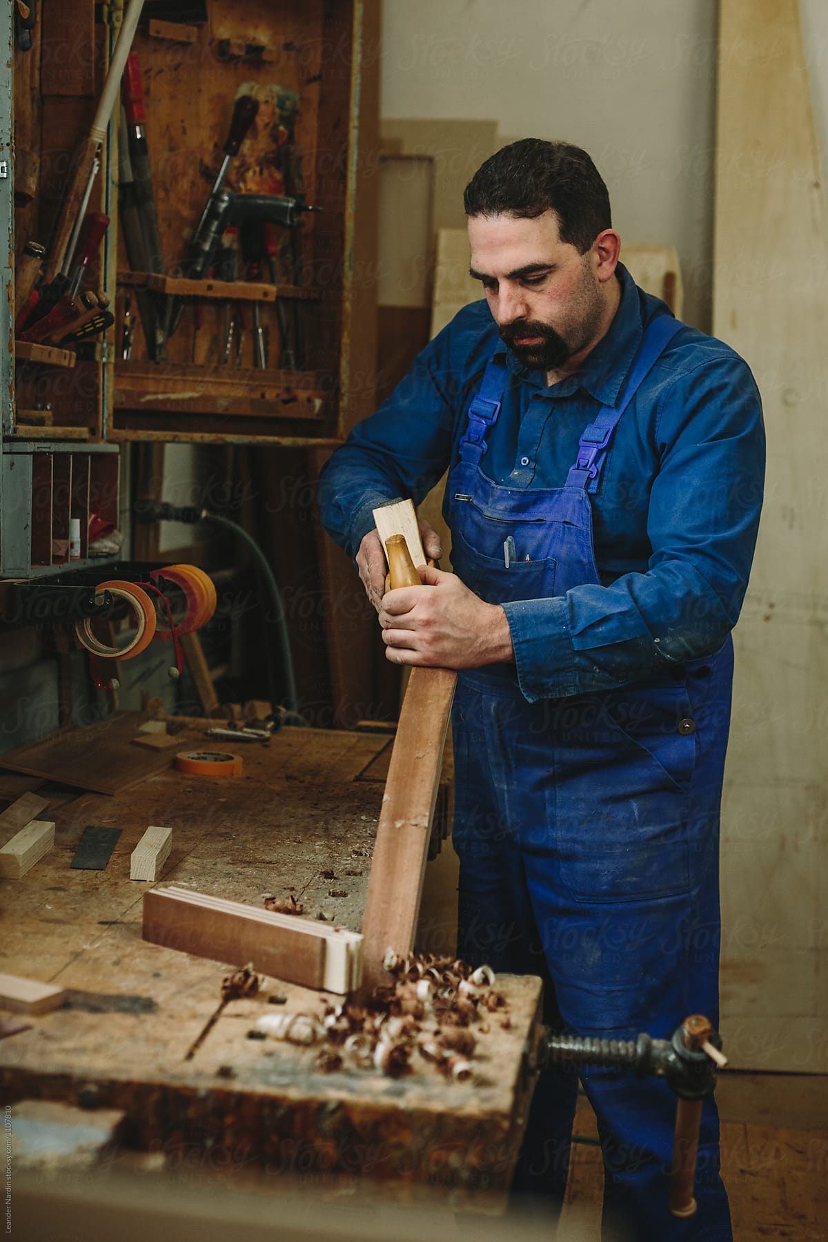 boat builder working with his wood plane in a wood workshop