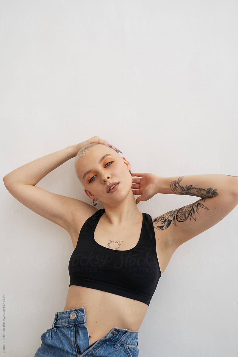 Cheerful sexy informal young woman with short hair and tattoo