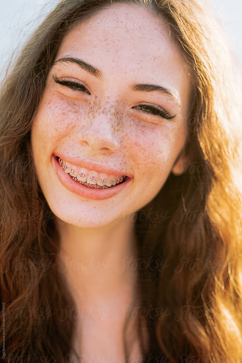 Closeup portrait of teenage freckled girl happily smiling