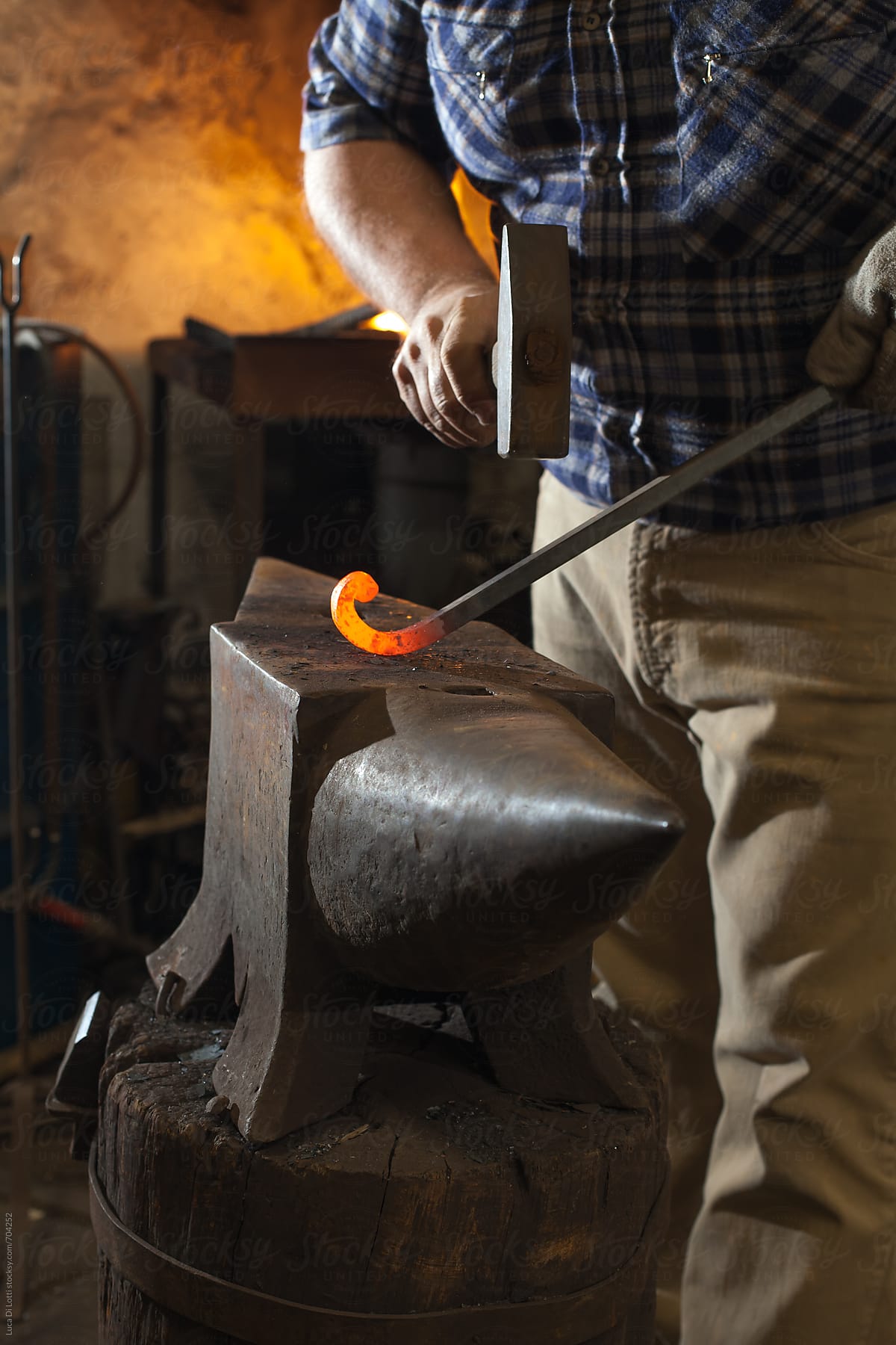 Blacksmith hammering a red-hot iron rod
