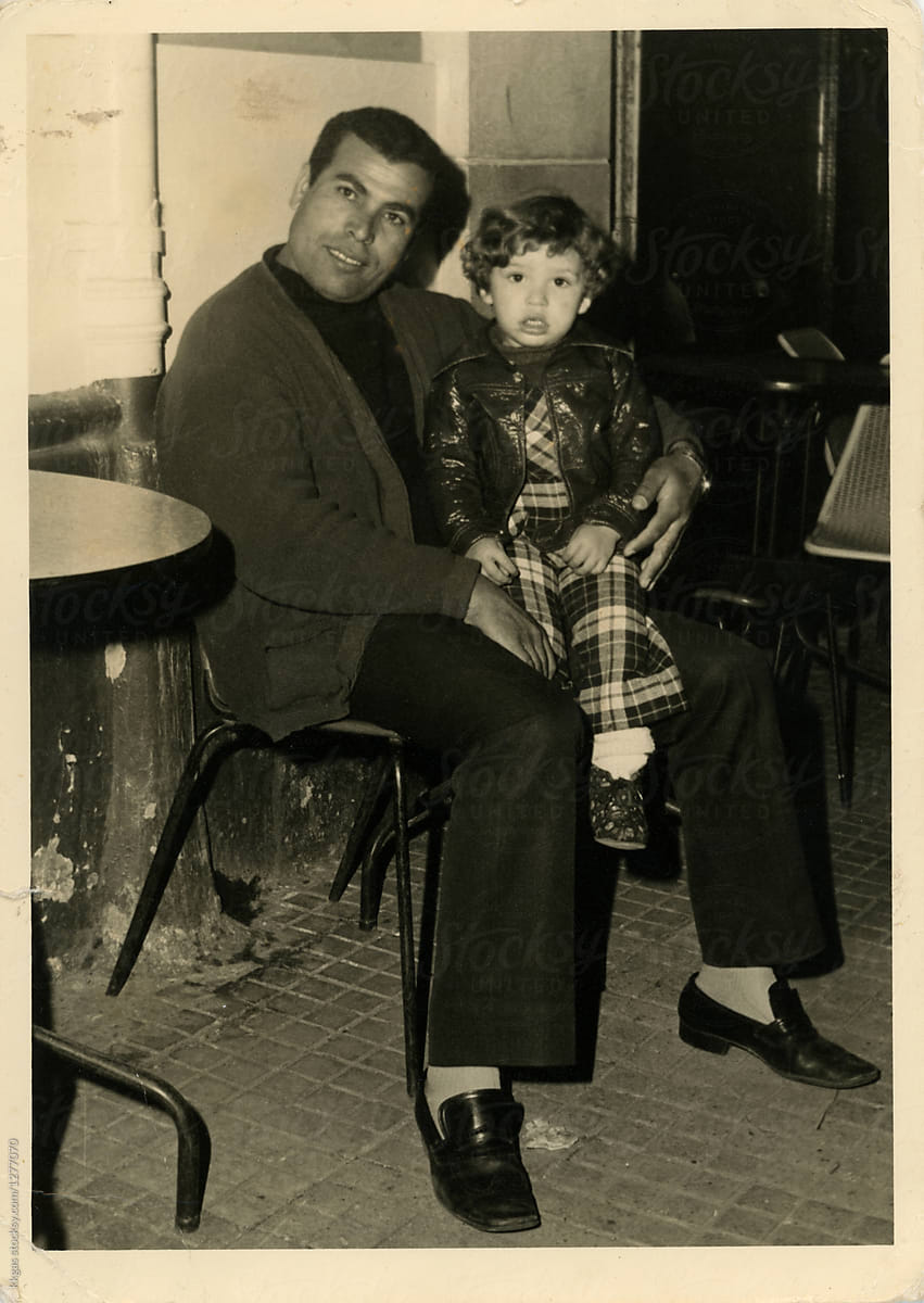 Scanned photo of child sitting on fathers lap