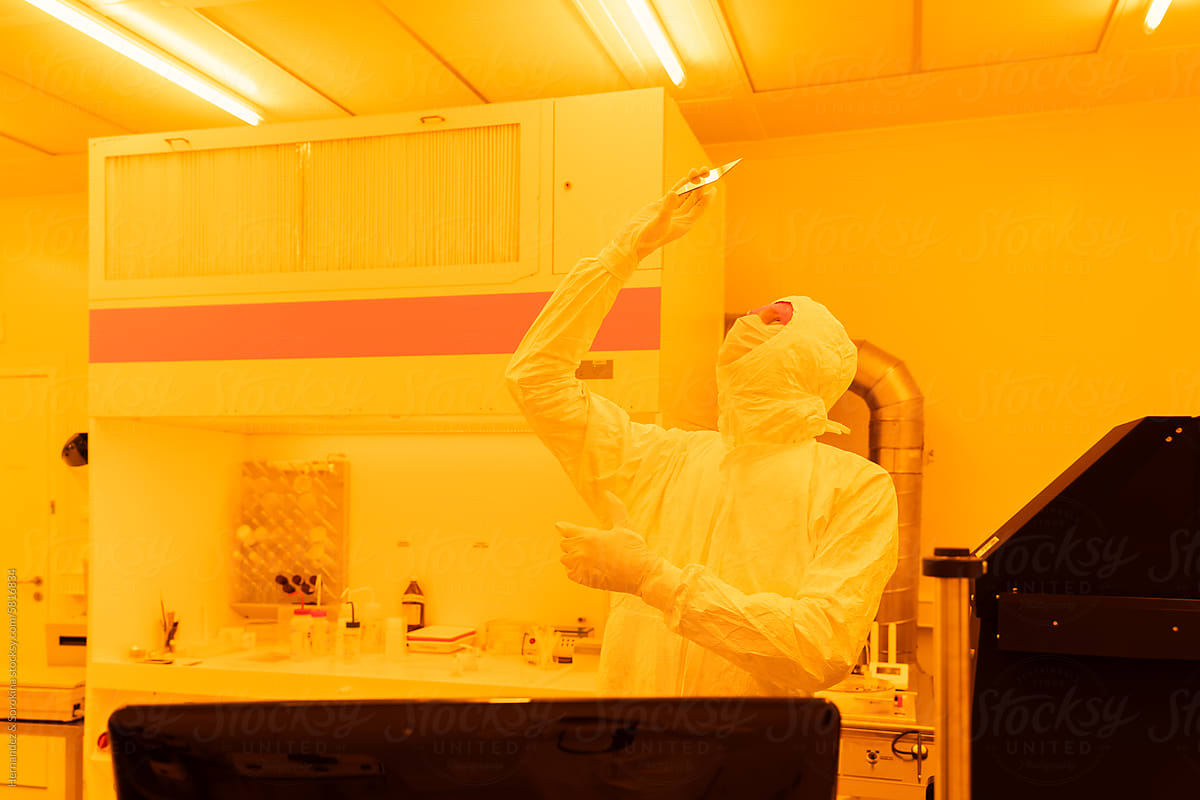 Scientist Analysing Sample In Yellow Light Clean Room