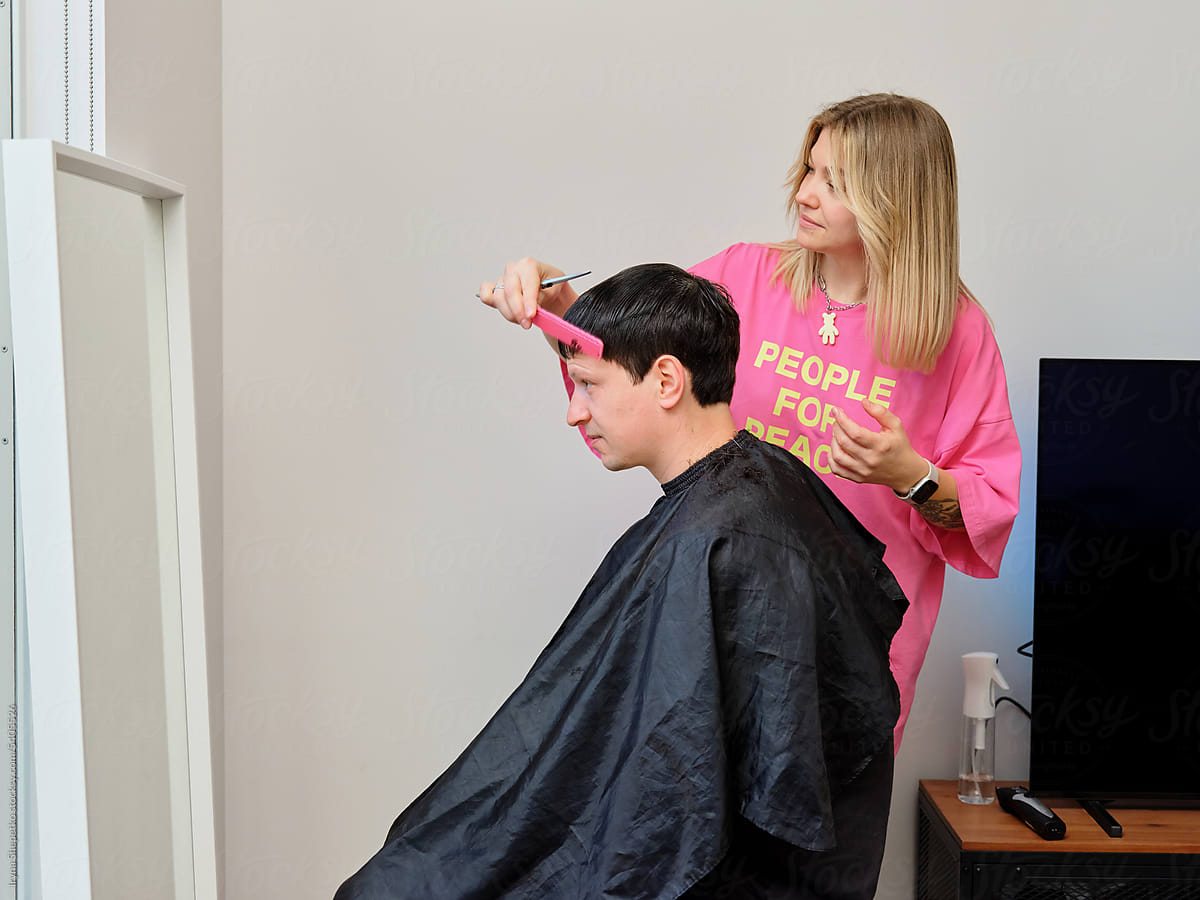 Woman cutting a man\'s hair close up