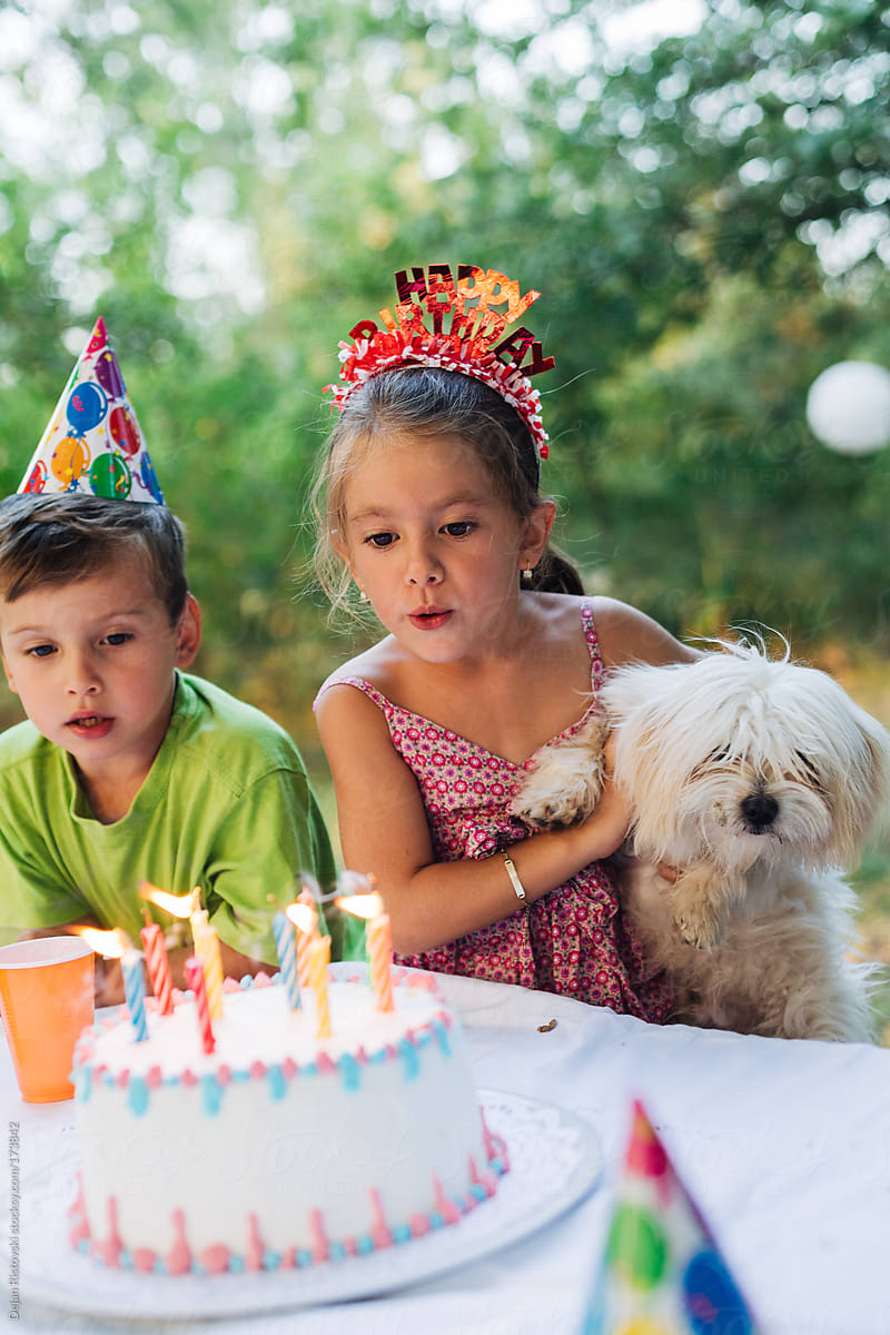 Girl blowing candles on a outdoor Birthday party