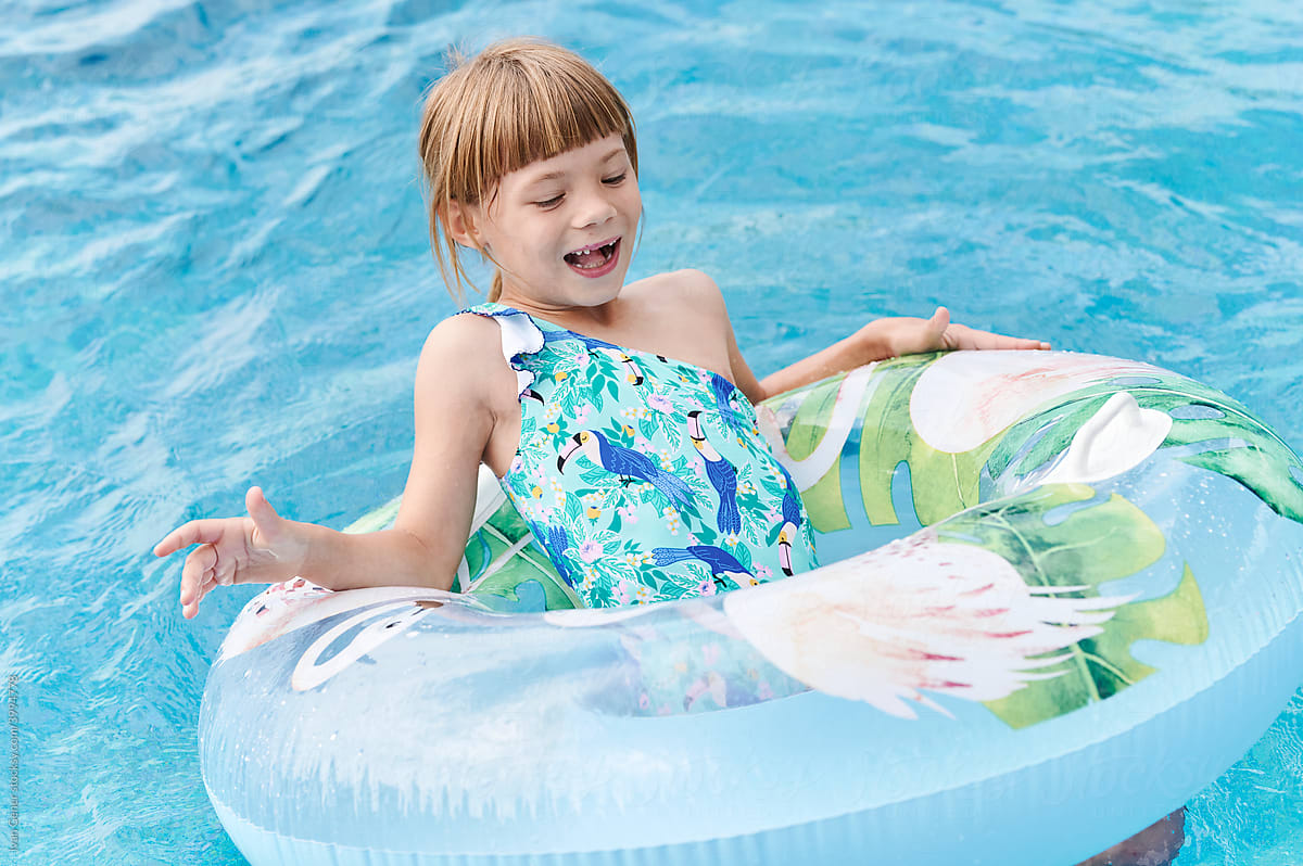Laughing little girl playing in a swimming pool