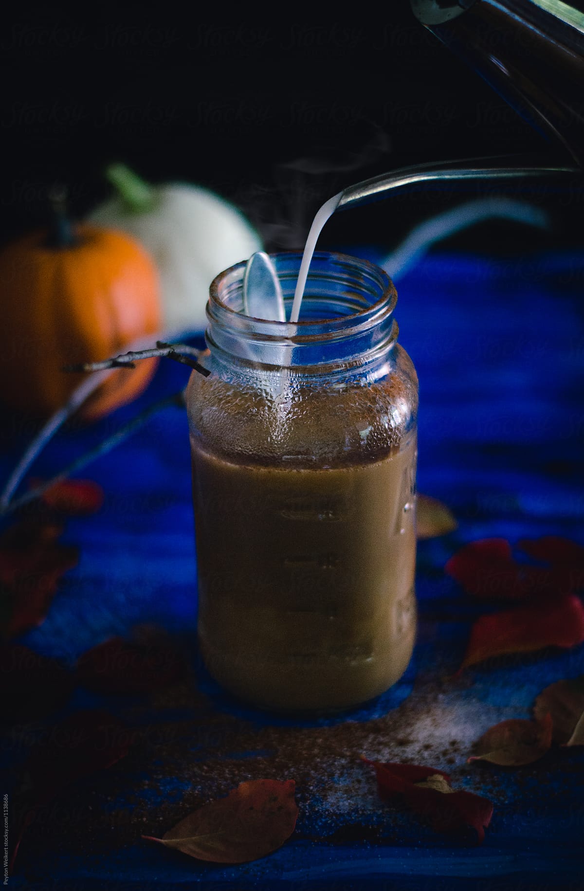 Pouring Cream into a Large Mason Jar of Pumpkin Spiced Coffee