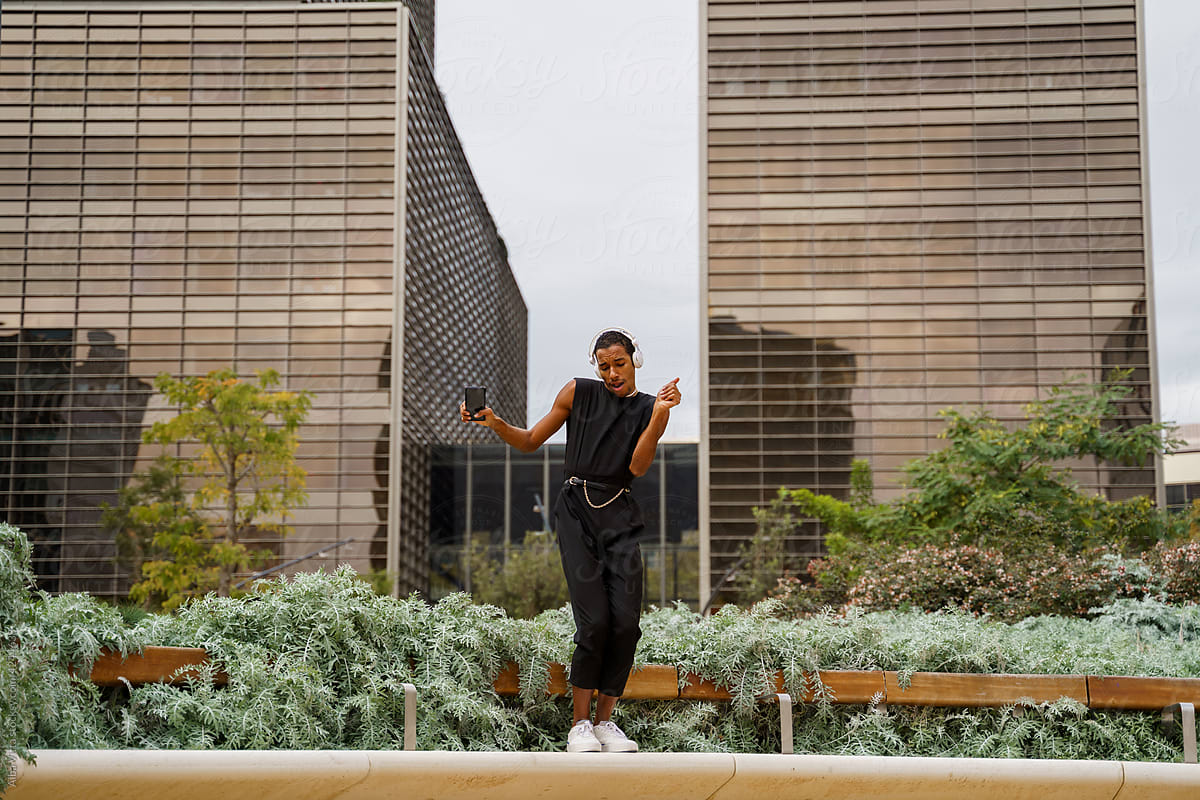 Stylish man dancing in front of office building