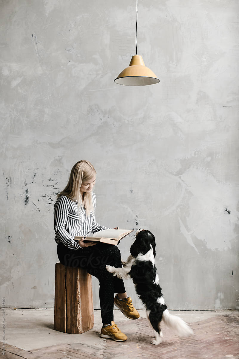 Dog leaning on owner reading book